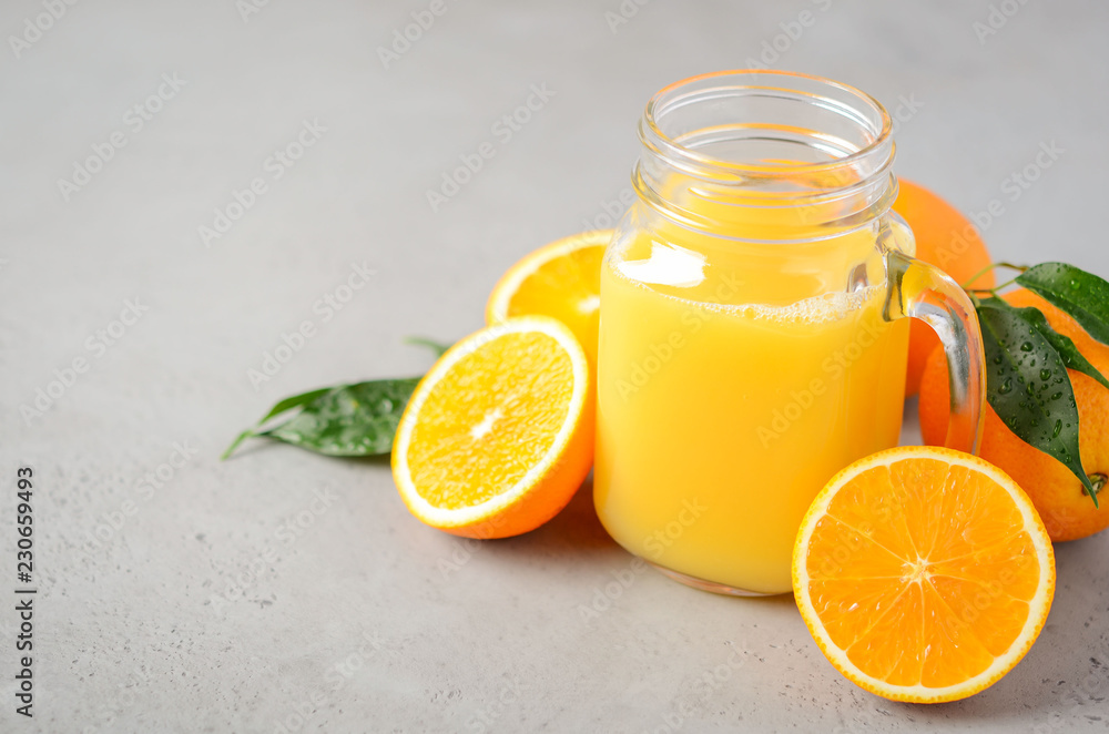Fresh orange juice in a jar on gray concrete background, selective focus, copy space. Fresh orange juice in a jar on gray concrete background, selective focus, copy space.