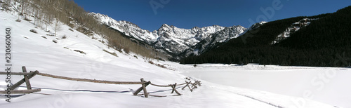 Beautiful snow covered Rocky Mountain peaks, split rail fence, near Vail Colorado photo