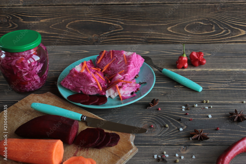 Sauerkraut with beets, on a platter and in a jar, on a wooden background. Sauerkraut with beets, on a platter and in a jar, on a wooden background.