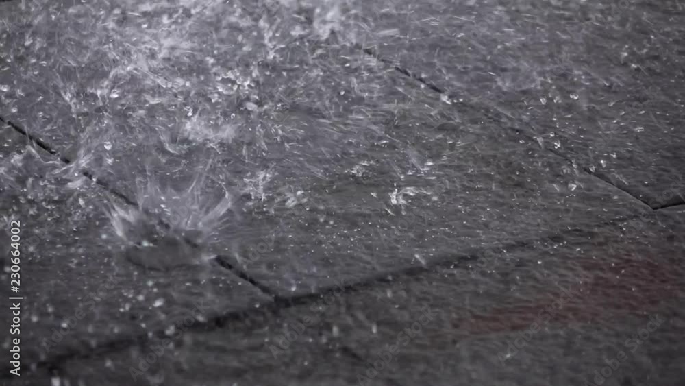 large rain drops hitting sidewalk slow motion large rain drops hitting sidewalk slow motion