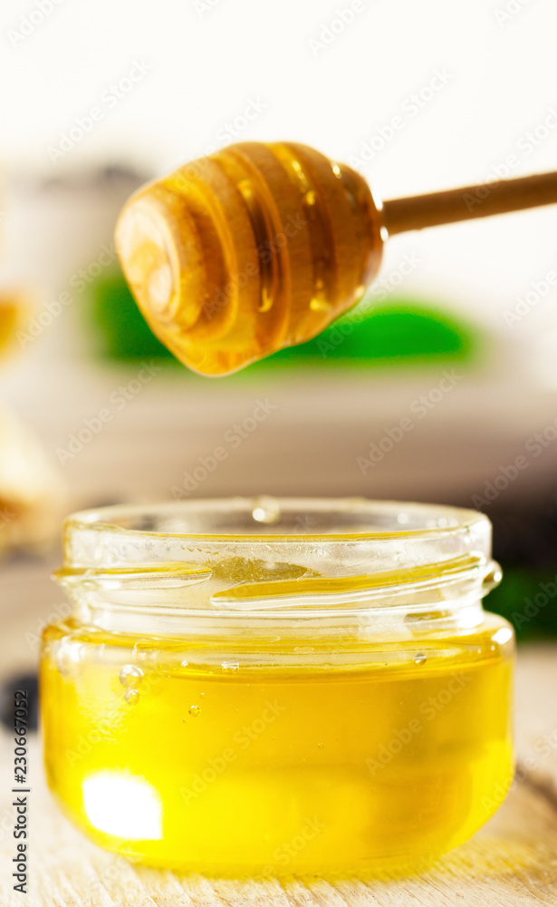 Honey with wooden honey dipper on wooden table Honey with wooden honey dipper on wooden table