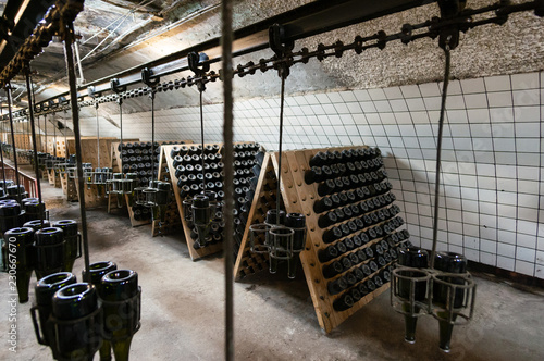 Stored bottles in the basement at the champagne factory, devices for shaking the drink