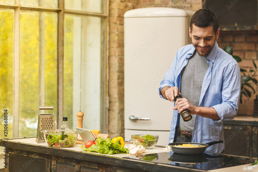 Man preparing delicious and healthy food in the home kitchen on a sunny day. Man preparing delicious and healthy food in the home kitchen on a sunny day.