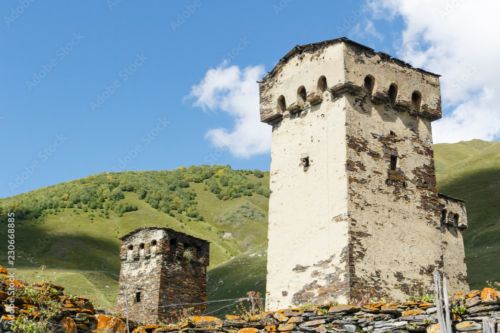 Old stone svan tower on street of Ushguli village in Svaneti, Georgia. Sunny day and sky with clouds background.
