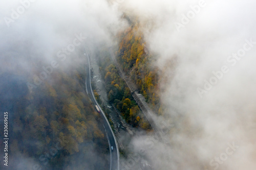 Foggy morning on the road in a mountain canyon with a truck passing on the road photo