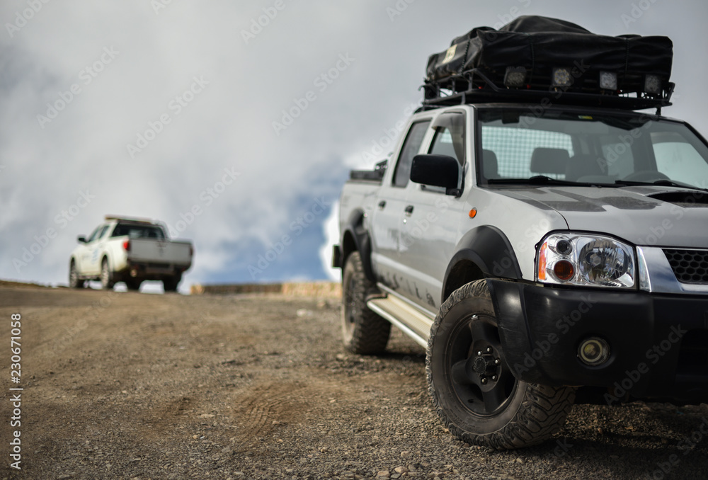 SUV pickup with roof trunk on mountain road - obrazy, fototapety, plakaty 