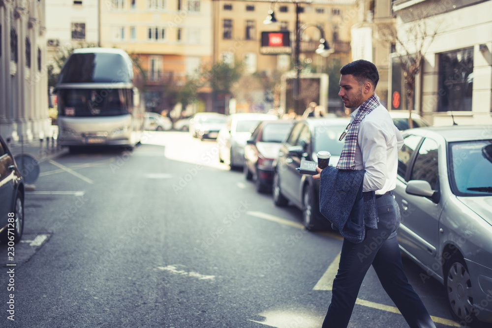 Caucasian businessman walking across the street Caucasian businessman walking across the street