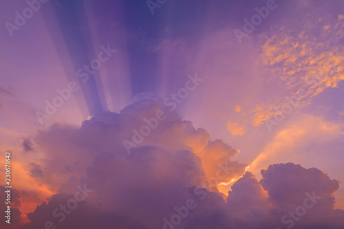 Beautiful radiant sun lighting in twilight. Colorful brightly soft and fluffy clouds on purple sky after hard raining. Background for business target or meteorology presentation or inspiration concept