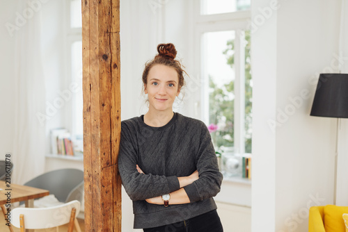 Friendly relaxed young woman leaning on a pole