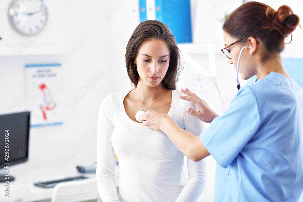 Adult woman being examined with stethoscope by female doctor Adult woman being examined with stethoscope by female doctor