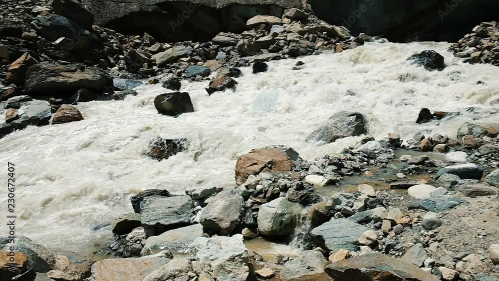 Mountain river flows out from under the glacier, a beautiful panoramic landscape, slow motion. Group of tourists on excursions, camera movement Mountain river flows out from under the glacier, a beautiful panoramic landscape, slow motion. Group of tourists on excursions, camera movement