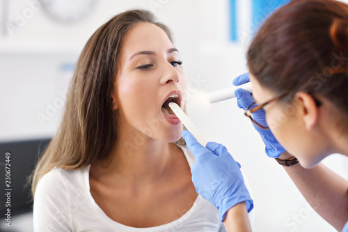 Adult woman having a visit at female laryngologist's office photo
