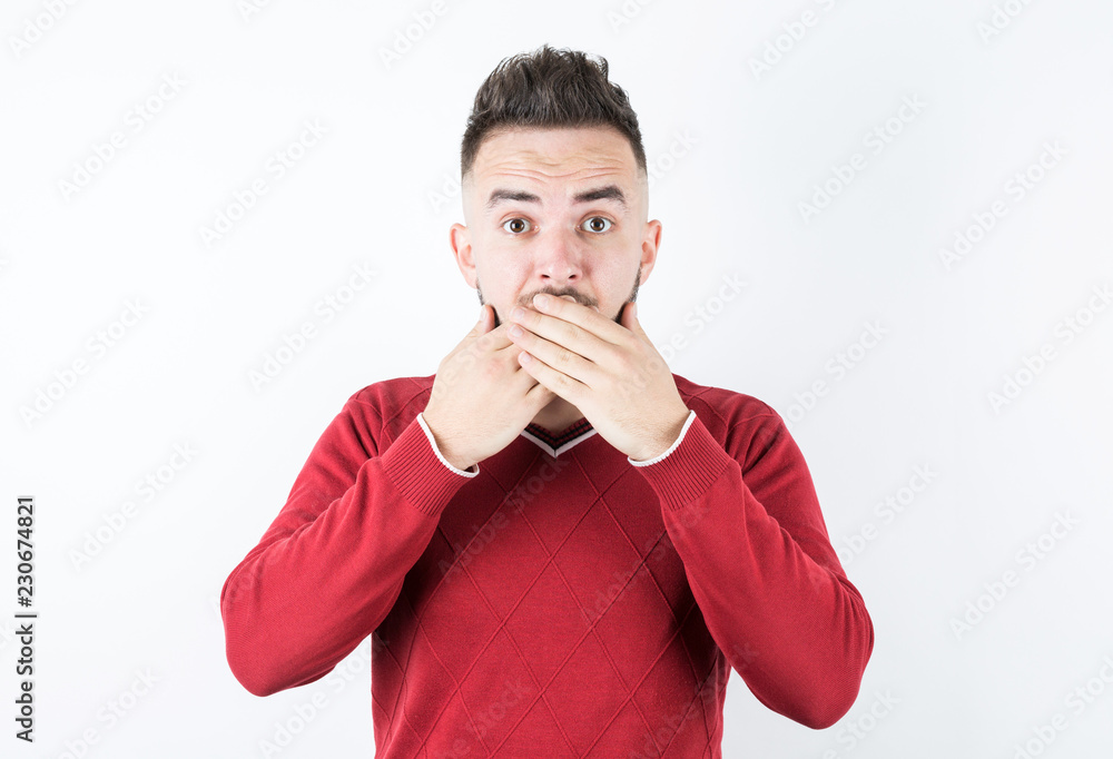 Portrait of young attractive male covering his mouth with hand Portrait of young attractive male covering his mouth with hand