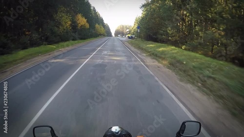 moving by empty autumn road by motorcycle, adventure travel, point of view photo