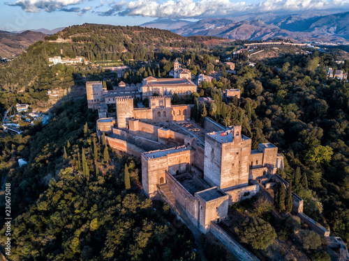 Aerial drone photo of The Alhambra Palace of Granada Spain at sunset. Vast castle fortress complex overlooking Granada, built by the Moorish Empire. 