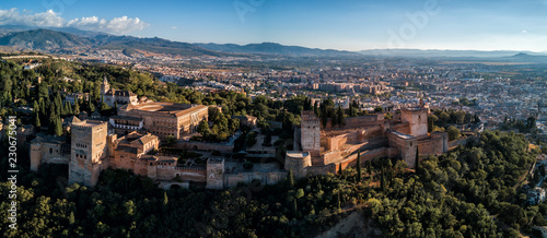Aerial drone panorama photo of The Alhambra Palace of Granada Spain at sunset.  Vast fortress castle complex overlooking Granada, built by the Moorish Empire.   © nick