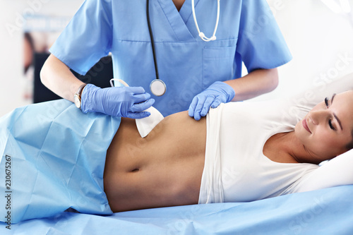 Adult woman having abdomen ultrasound tests at female doctor s office