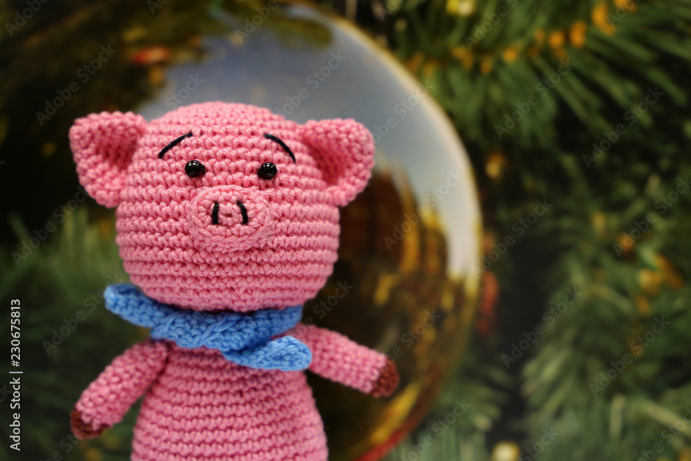 Knitted toy piggy on christmas decorations background. Chinese new year of the Pig, symbol 2019, Zodiac sign for greetings card Knitted toy piggy on christmas decorations background. Chinese new year of the Pig, symbol 2019, Zodiac sign for greetings card