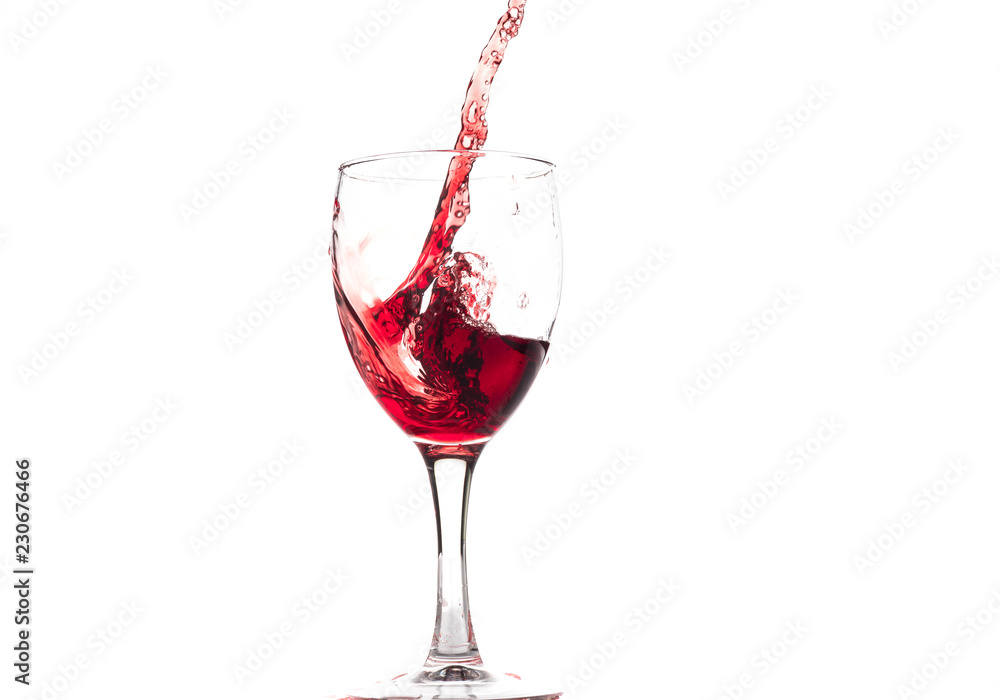 Red wine falls into a glass and creates splash and splashes on a white background. Red wine falls into a glass and creates splash and splashes on a white background.