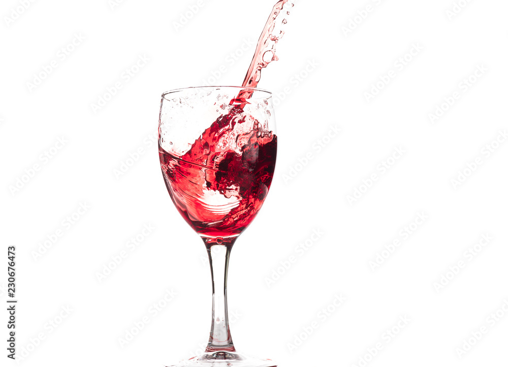 Red wine falls into a glass and creates splash and splashes on a white background. Red wine falls into a glass and creates splash and splashes on a white background.