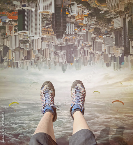 Legs of a woman in sneakers relaxing in sky. Invert city upside down .Future modern business industry concept: Big city on amazing sky at Bangkok, Thailand, Asia