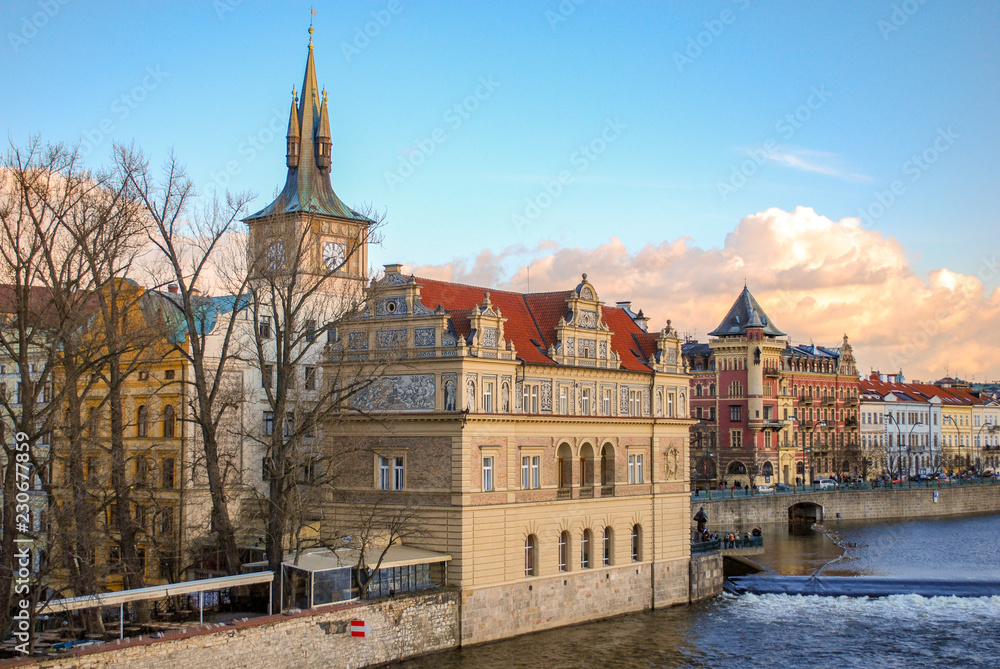 Clock tower and buildings on the riverfront in Prague Czech Republic Clock tower and buildings on the riverfront in Prague Czech Republic