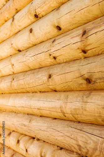 close up wall of round wooden logs.