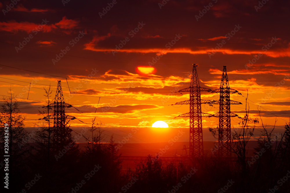 Silhouette of high voltage posts at sunset. Norilsk.