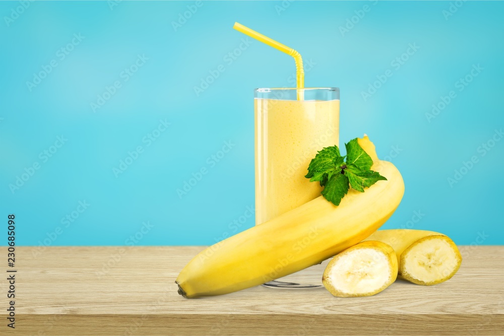 Tasty banana milkshake on wooden table