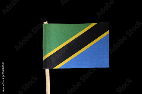 A national official flag of Tanzania on toothpick on black background. A yellow edged black diagonal band. Upper triangle is green and the lower is blue photo