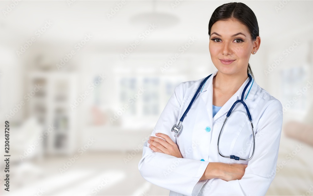 Attractive young female doctor with blurred hospital Attractive young female doctor with blurred hospital