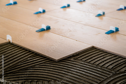 Wood texture tiles shot close up at the time of construction work, notched trowel tracks in tile mortar © RedHanded