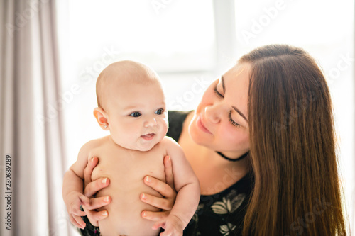 A Portrait of happy baby with cheerful mother at home bedroom