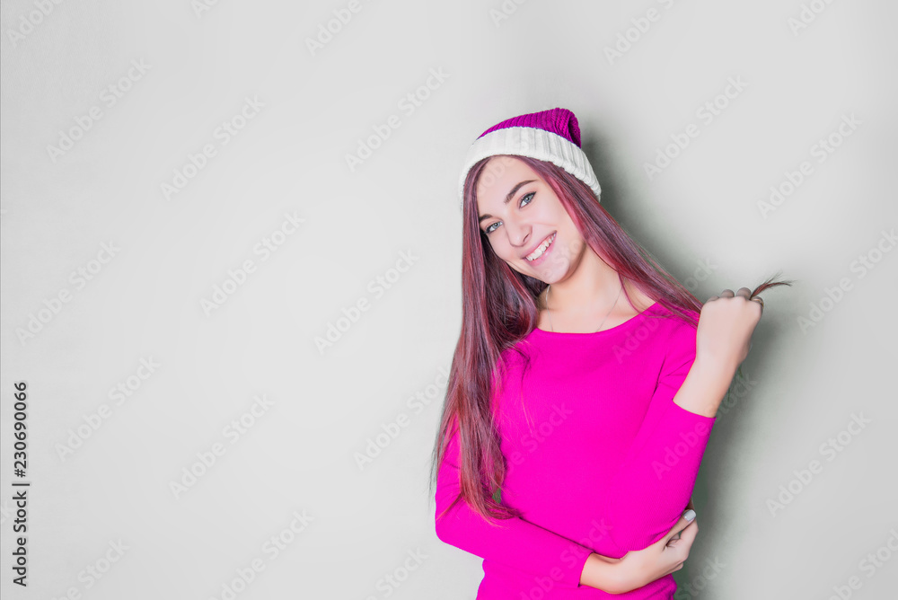 Beautiful female model wear pink santa hat with pink hair. Smiling teenage girl. on white background. Positive emotional Santa girl. Concept of selling and Christmas shopping. Xmas. Beautiful female model wear pink santa hat with pink hair. Smiling teenage girl. on white background. Positive emotional Santa girl. Concept of selling and Christmas shopping. Xmas.