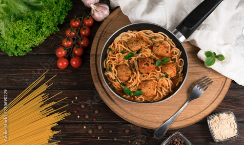 spaghetti with meat and tomatoes on a wooden background