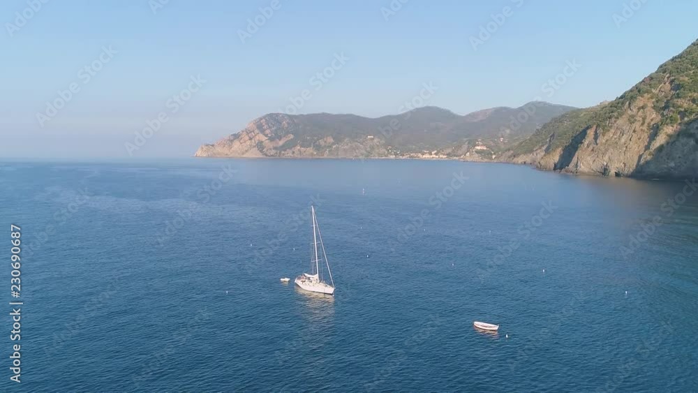 Aerial: Yacht parked in open sea Close to mountain cliff shore Aerial: Yacht parked in open sea Close to mountain cliff shore