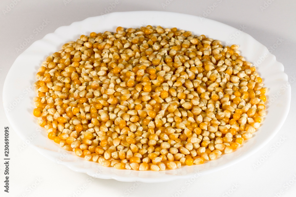 White plate with unpopped corn (popcorn kernel's) White plate with unpopped corn (popcorn kernel's)