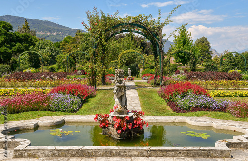 Giardino fiorito con fontane, archi, aiuole e colline sullo sfondo, Villa Pallavicino, Stresa, Lago Maggiore, Italia photo