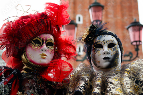 Carnival pair red-black-gold mask and costume at the traditional festival in Venice, Italy