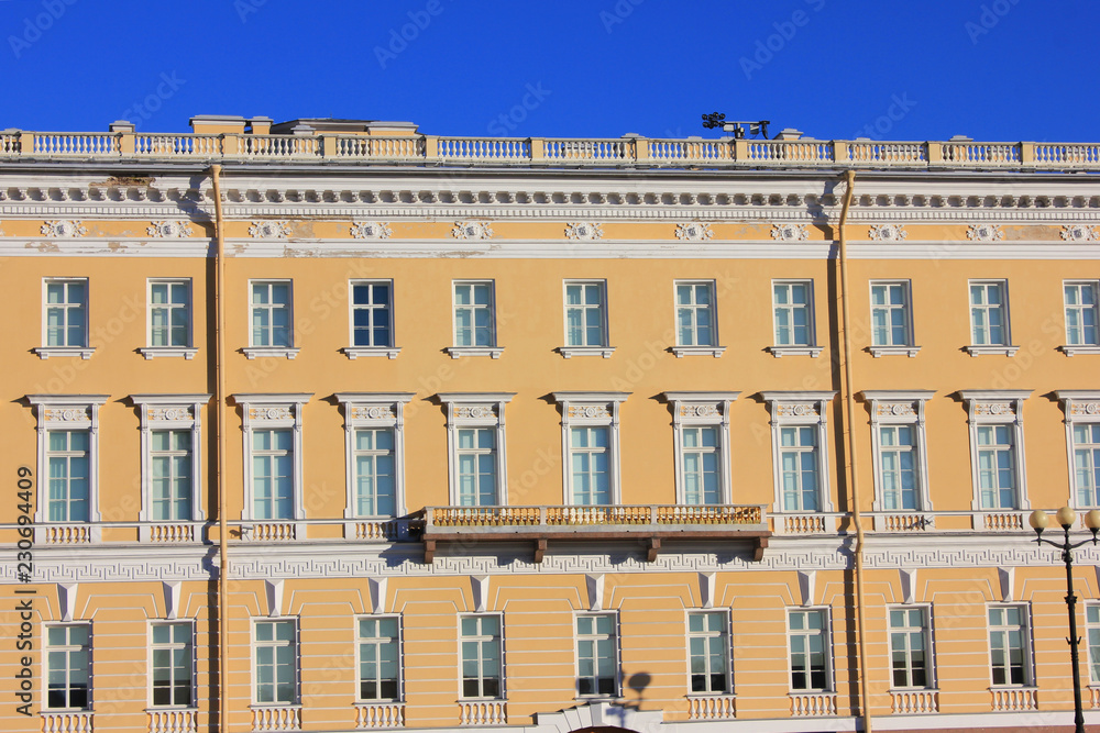 Obraz premium Old Historic Building Facade of Soft Yellow and White Color with Windows in Saint Petersburg, Russia. Classic Russian City House Exterior, Front View of Traditional European Style Building in Russia