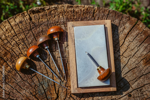 Engraving shtikhel and grindstone on a wooden background. photo