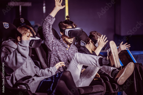 friends in virtual glasses watching movies in the cinema with special effects in 5d photo