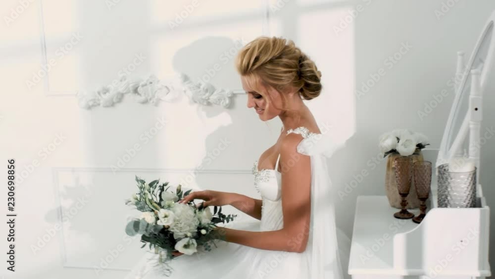 beautiful sexy blonde bride posing in wedding dress with bouqet beautiful sexy blonde bride posing in wedding dress with bouqet