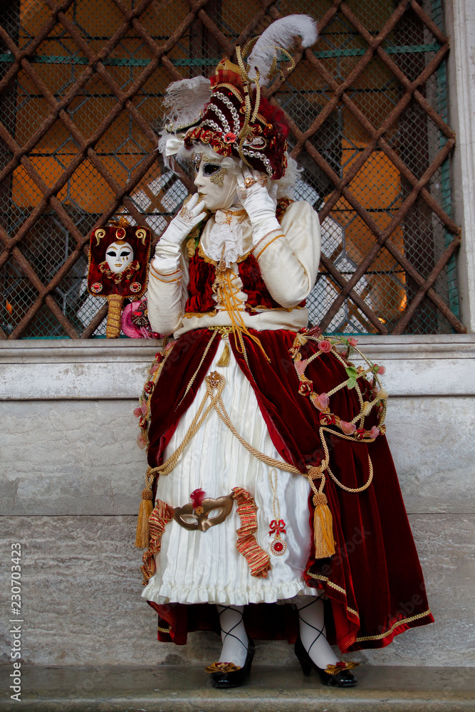 Carnival red-white mask and costume at the traditional festival in Venice, Italy Carnival red-white mask and costume at the traditional festival in Venice, Italy