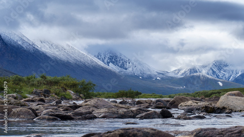 Northern landscape. Mountain river in the snow-capped mountains. Russia  The Urals