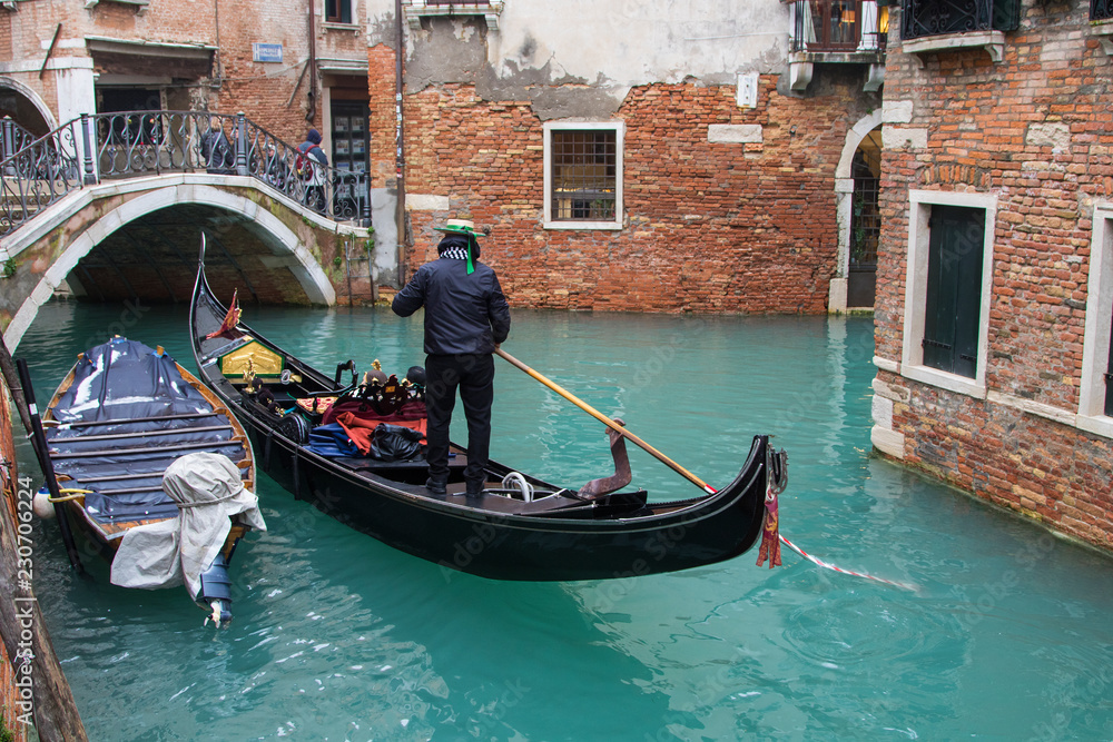 Gondolier in a little canal of Venice