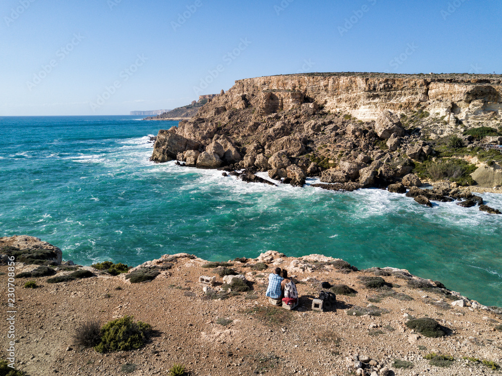 Aerial drone photograph of waves crashing into the rugged coastline of Malta. Tiny island country in the Mediterranean Sea, Europe.