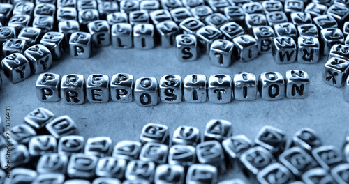 Preposition - Word from Metal Blocks on Paper - Concept Photo on Table
