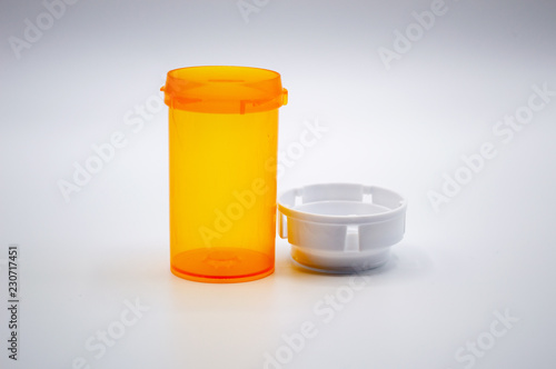 Empty yellow medicine bottle with a white cap isolated on a white background