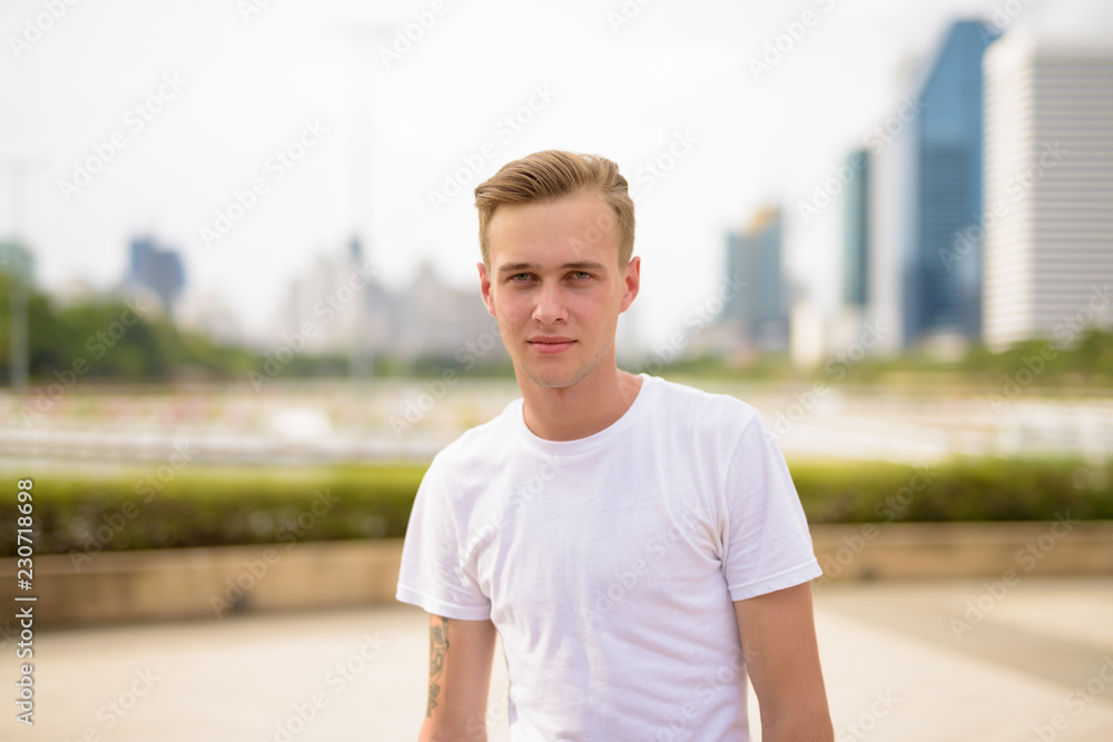 Young handsome man with blond hair relaxing at the park Young handsome man with blond hair relaxing at the park